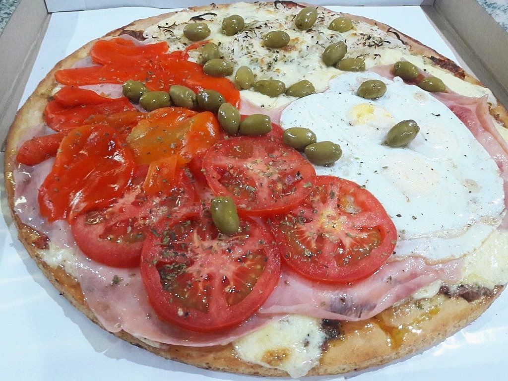 Pizza con morrones, tomate en rodajas y huevo frito